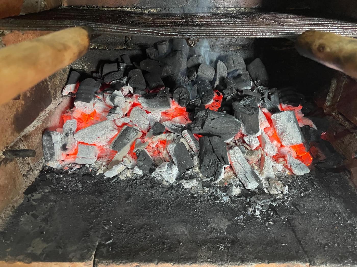 Charcoal glowing in a brick grill